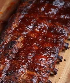 ribs covered in bbq sauce on a cutting board