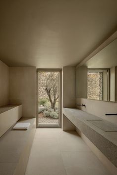 an empty bathroom with two sinks and a large open door leading to the outside area