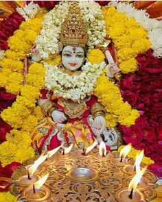 the idol is surrounded by flowers and candles