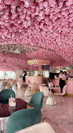 the interior of a restaurant with pink flowers hanging from the ceiling