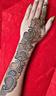 a woman's hand with henna tattoos on her left arm and the bottom half of