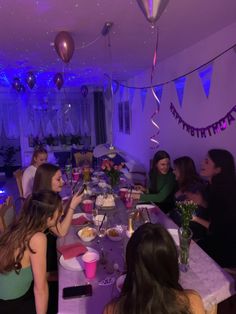 a group of people sitting around a table with food and drinks in front of them