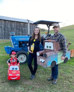 a man and woman standing next to a child in a toy car