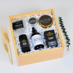 an open gift box containing three bottles of wine, soap and other personal care products