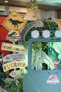 there are many dinosaur signs on display in this shop window, including one for the children's car