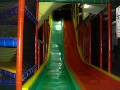 an indoor play area with slides and climbing ropes