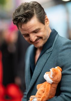 a man in a suit holding a teddy bear