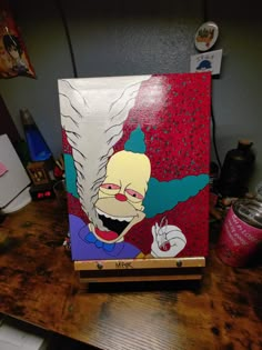 an image of a cartoon character painted on a piece of wood that is sitting on top of a table