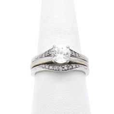 a white gold ring set with diamonds on the band and an oval cut diamond in the center