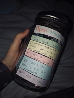 a person holding a jar with sticky notes on it