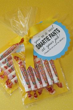 small candy sticks wrapped in cellophane and tied with a yellow ribbon on a yellow background