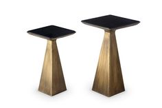 two gold pedestals with black tops on white background, one is turned upside down