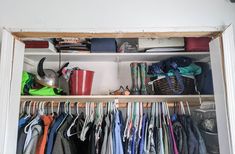 a closet filled with lots of clothes and other items on shelves next to a wall