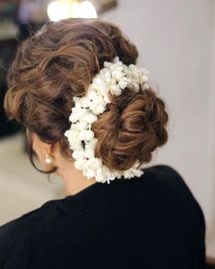 a woman with flowers in her hair is getting ready to go into the wedding ceremony