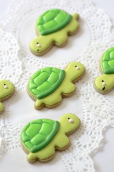 decorated cookies in the shape of turtles on a doily