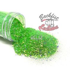 a jar filled with green glitter sitting on top of a white table