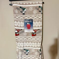 a towel hanging on the wall with peanuts and snoopy skiing down it's side