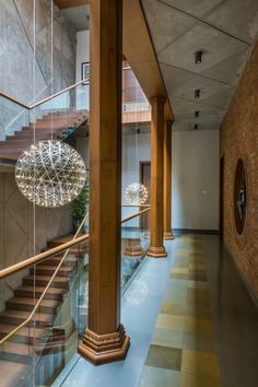 an elegant staircase with glass railing and chandelier hanging from it's sides