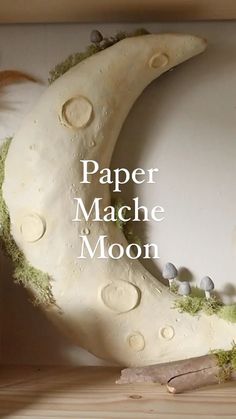 paper mache moon sitting on top of a wooden shelf