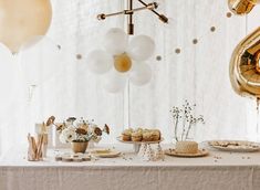 a table topped with lots of desserts and balloons