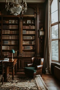 a chair and table in front of a large window with bookshelves on both sides