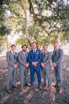 a group of men standing next to each other under a tree