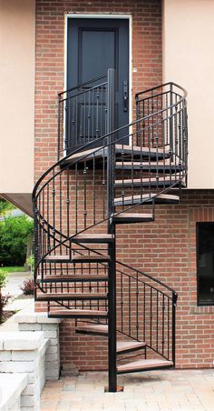 there is a spiral staircase in front of the door and brick building with steps leading up to it