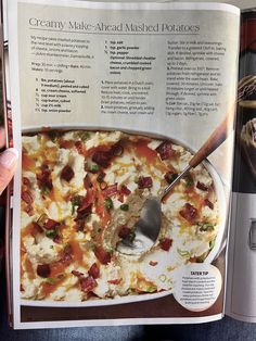 a person is holding up a magazine about baked potatoes and other things in the kitchen