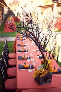 a long table set up with place settings for an outdoor dinner in the park or garden