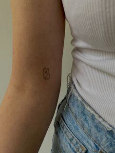 a woman's arm with a small tattoo on the left side of her arm