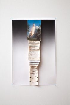 a stack of books sitting on top of a white wall next to a painting with a castle in the background