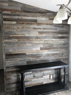 a wood paneled wall with two lamps and a bench in the corner on top of it