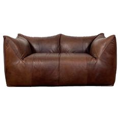 a brown leather couch sitting on top of a white floor