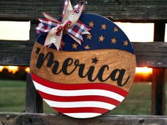 a wooden sign with the word merica painted on it and an american flag bow