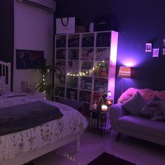 a bed room with a neatly made bed and purple lighting