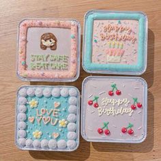 four decorated birthday cakes sitting on top of a wooden table