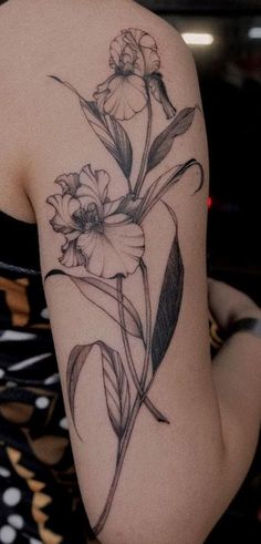 a woman with a tattoo on her arm has flowers in the middle of her arm