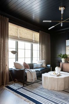 the living room is decorated in black and white with striped rugs on the floor