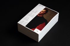 a stack of business cards with an image of a man wearing a black and red outfit