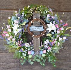 an easter wreath with flowers, eggs and a cross