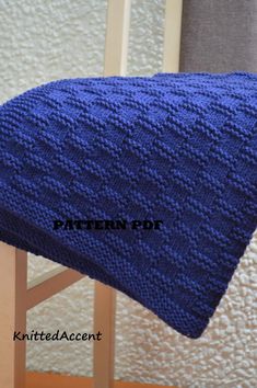 a blue knitted blanket sitting on top of a wooden chair