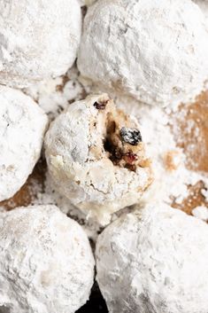 powdered sugar donuts with cranberries and raisins in the middle