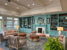 a living room filled with lots of furniture and bookshelves next to a fire place