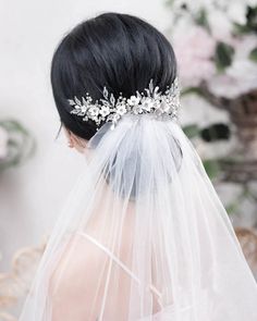 the back of a bride's head wearing a veil and bridal hair comb