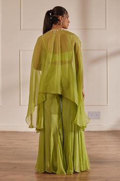 Green sheer cape with cutdana embellished floral motifs. Comes with crop top and sharara.
Components: 3
Pattern: Embroidered
Type Of Work: Cutdana,Sequin,Pearl
Neckline: Cape: Tie-up, Crop top: U-neck
Sleeve Type: Cape: Cape sleeves, Crop top: Sleeveless
Fabric: Semi Raw Silk, Georgette, Viscose Organza, Lining: Shantoon
Color: Green
Other Details: 
Attached lining
Closure:
Cape: Front drawstring
Crop Top: Back hook
Sharara: Side zip
Occasion: Cocktail,Sangeet - Aza Fashions Bollywood Style Wedding Kurta With Cape Sleeves, Designer Sharara With Silk And Cape Sleeves, Designer Silk Sharara With Cape Sleeves, Festive Sharara With Cape Sleeves In Organza, Chanderi Sets With Cape Sleeves For Festivals, Festive Organza Sharara With Cape Sleeves, Designer Organza Sharara With Cape Sleeves, Festive Anarkali Top With Sheer Dupatta, Organza Sharara With Dupatta And Cape Sleeves