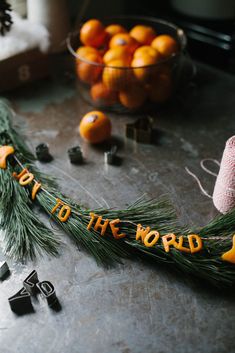 some oranges are laying on a table with the words to the world spelled out