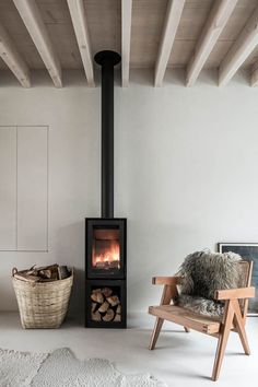 a living room with a chair, fire place and wood burning in the fireplaces