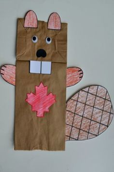 a brown paper bag with a bear and maple leaf cut out on it's side