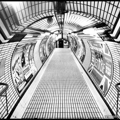 an empty subway station with tiled floor and walls, in black and white photo taken from the inside