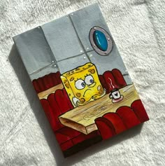 a piece of art that looks like spongebob sitting at a table